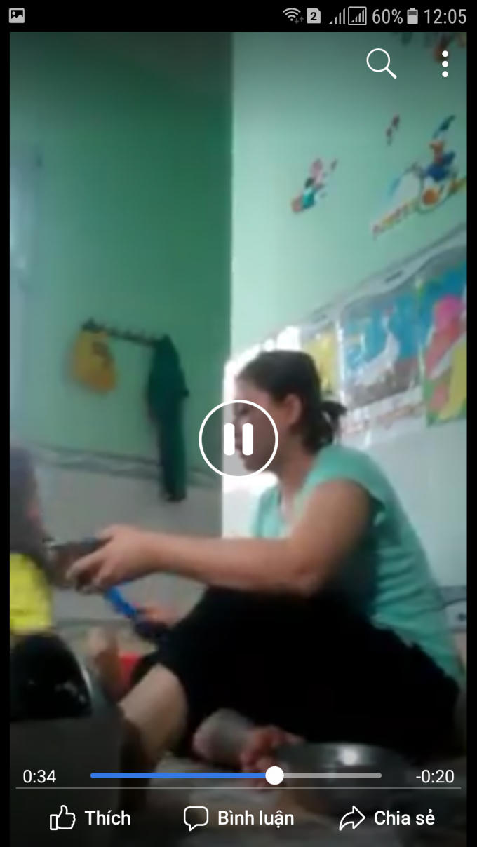 Bảo mẫu dùng que mũ đánh bé gái khi đang cho trẻ ăn (Ảnh cắt từ đoạn clip được đăng trên mạng xã hội)