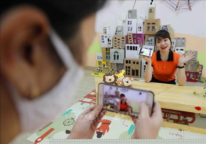 Cô giáo trường Mầm non Tràng An, quận Thanh Xuân (Hà Nội) ứng dụng phần mềm công nghệ để chèn âm thanh lên ảnh, tạo video tiết kể chuyện cho trẻ hấp dẫn và lôi cuốn hơn. Ảnh: Thanh Tùng/TTXVN