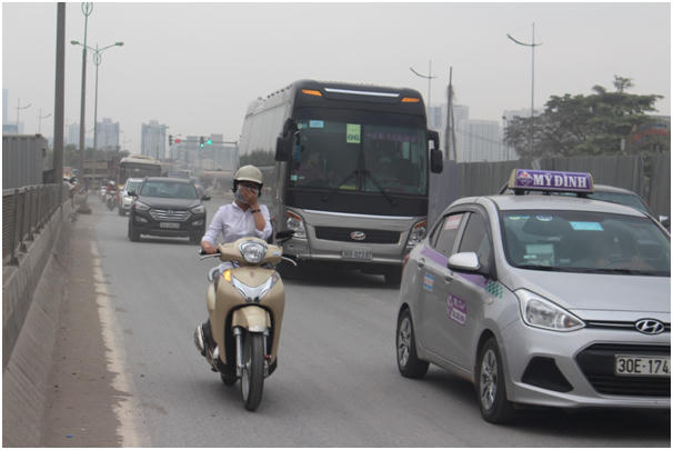Một c&ocirc; g&aacute;i lưu th&ocirc;ng tr&ecirc;n đường ngo&agrave;i đeo khẩu trang c&ocirc; c&ograve;n lấy tay che miệng để tr&aacute;nh bụi.