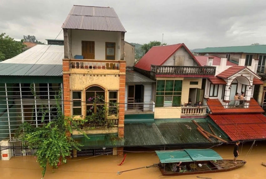 Đường phố ở phường Yên Bái (tỉnh Lào Cai) bị ngập sâu trong nước, một số người dân phải sử dụng tạm thuyền để làm phương tiện di chuyển.