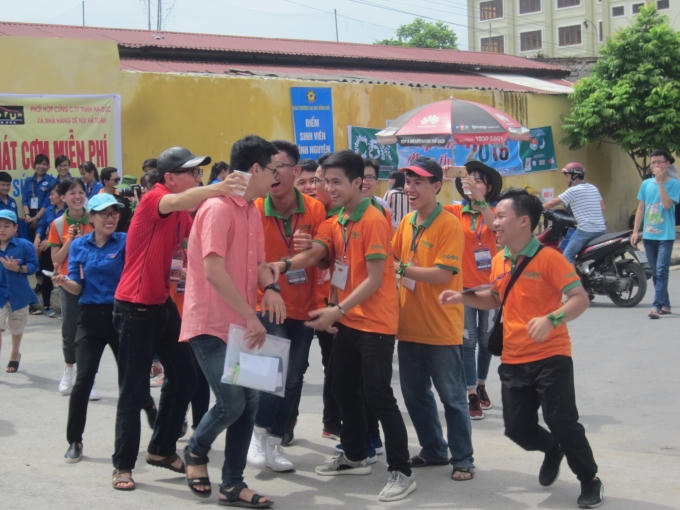 Thí sinh đầu tiên bước ra cổng trường trường trong sự chào đón nhiệt tình của các tình nguyện viên.