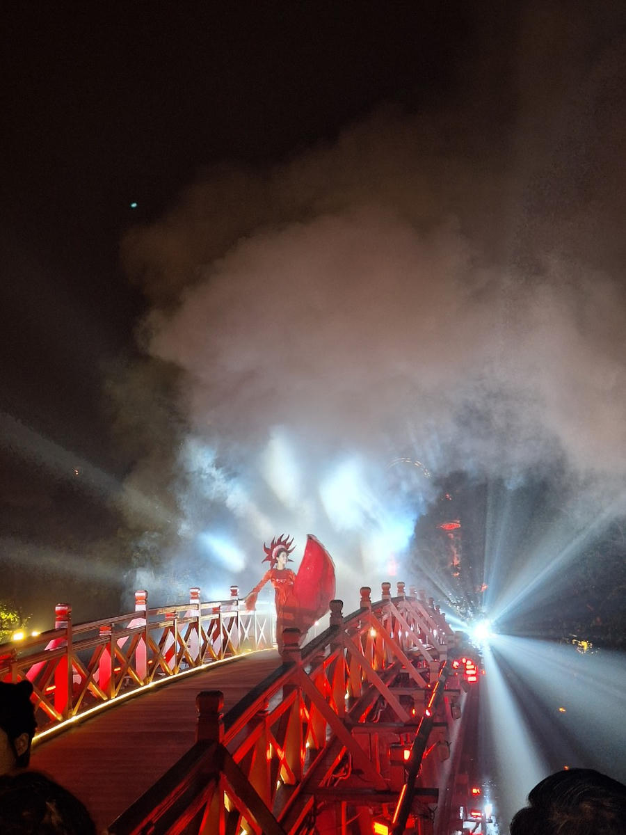 Du khách thưởng thức điệu múa mặt trời trên cầu Thê Húc. (Ảnh: Thùy Dương)