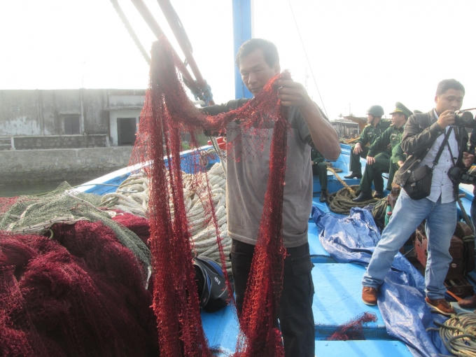 Ngư dân Đặng Viết Tuyên với tấm lưới bị hải cảnh Trung Quốc phá