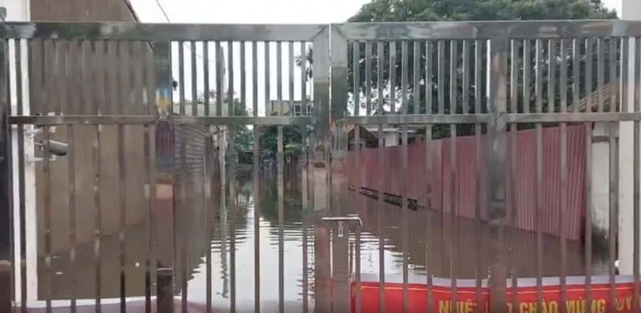 Khu vực cổng trường nhìn ra bên ngoài cũng đang chìm trong biển nước.