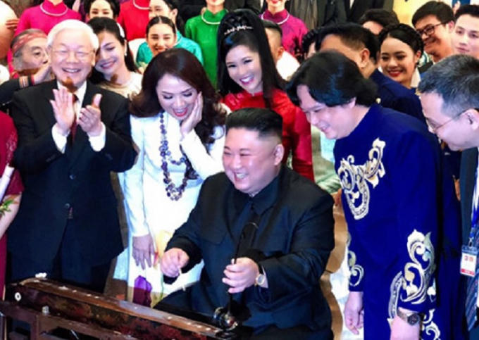 Tổng bí thư, Chủ tịch nước Nguyễn Phú Trọng đứng bên cạnh khi Chủ tịch Kim Jong-un chơi thử đàn bầu.