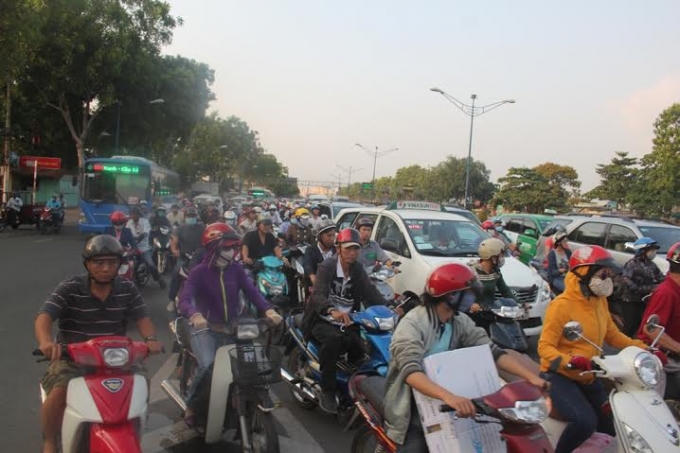 Xe máy và xe ô tô chen chúc nhau đợi.