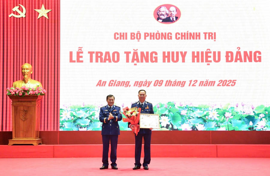 Đồng chí Đại tá Nguyễn Thái Dương - Ủy viên Ban Thường vụ Đảng ủy, Phó Chính ủy Bộ Tư lệnh Vùng Cảnh sát biển 4 trao huy hiệu 40 năm tuổi Đảng và tặng hoa chúc mừng đồng chí Thiếu tướng Nguyễn Văn Dũng