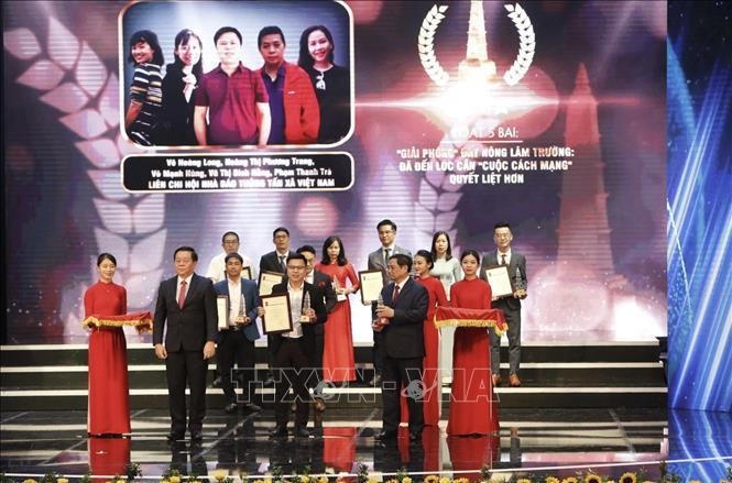 Thủ tướng Phạm Minh Chính và Bí thư Trung ương Đảng, Trưởng ban Tuyên giáo Trung ương Nguyễn Trọng Nghĩa trao giải A cho các tác giả. Ảnh: Trần Việt/TTXVN