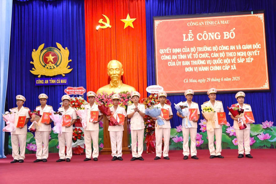 Đại tá Nguyễn Phúc Cường - Phó Giám đốc Công an tỉnh Cà Mau, trao quyết định và tặng hoa chúc mừng các Trưởng Công an xã.