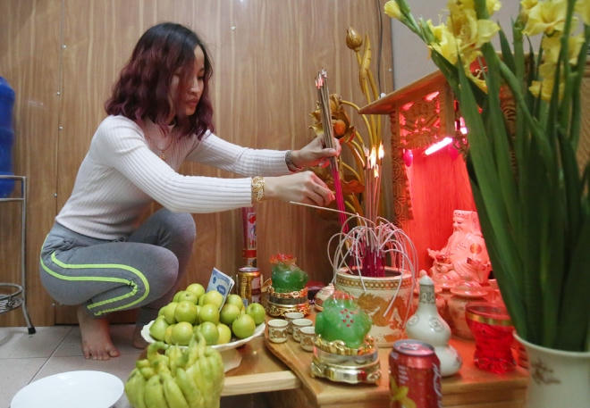 Chị Bùi Huyền Trang mang những nén hương từ đình về ban thờ thần tài nhà mình, cầu mong một năm nhiều tài lộc, nhiều may mắn.