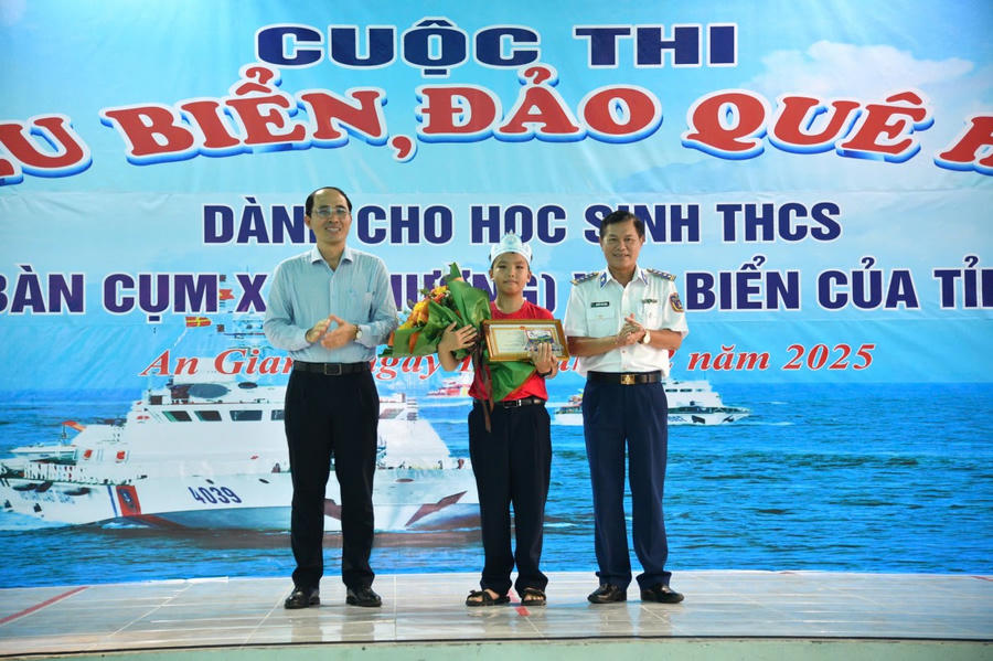 Đại tá Nguyễn Thái Dương - Uỷ viên Ban Thường vụ Đảng uỷ, Phó Chính uỷ Bộ Tư lệnh Vùng Cảnh sát biển 4 và Ông Hồ Văn Được - Phó Trưởng Phòng Giáo dục phổ thông, Sở Giáo dục & Đào tạo tỉnh An Giang trao giải nhất cho Em Trần Đăng Tiến, học sinh lớp 6A4, Trường THCS & THPT Võ Văn Kiệt