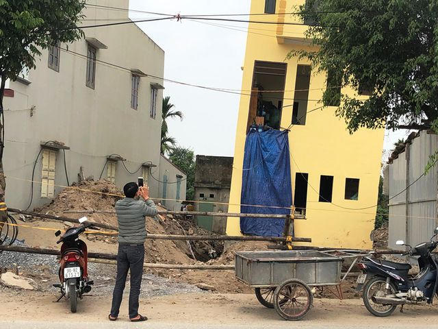 Nhiều người khi đi qua đường DT491 thấy ngôi nhà bị nghiêng đã hiếu kỳ đứng lại chụp ảnh.