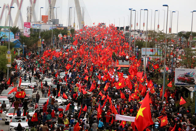 Đến 15h 50, chiếc xe buýt mui trần chở Ban huấn luyện và các cầu thủ U23 Việt Nam mới qua cầu Nhật Tân. (Ảnh Tiến Nguyên )