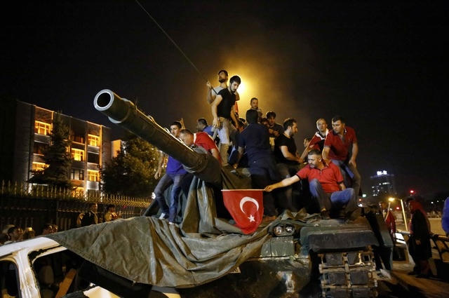 Người dân đứng trên một xe tăng quân đội ở Ankara (Ảnh: Reuters)