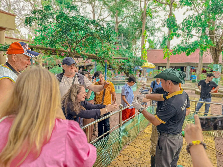Du khách nước ngoài hứng thú tìm hiểm về những nét độc đáo của trại rắn Đồng Tâm.