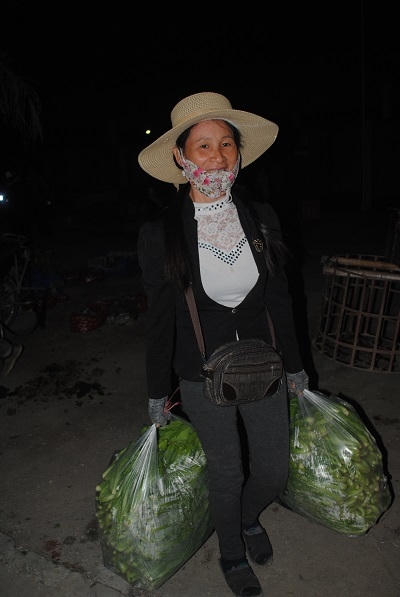 Một thương lái vui mừng khi mua được những bịch rau vừa ý. Ảnh Duy Ngợi