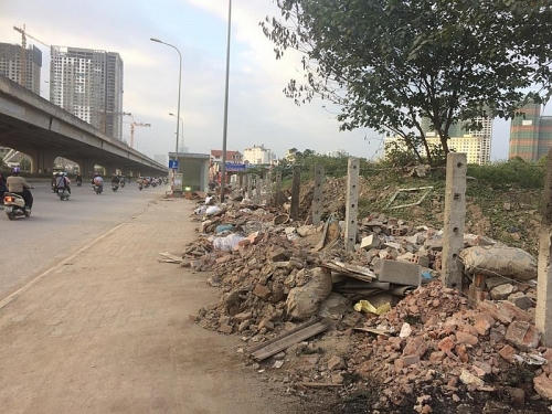 Một lô đất sát đường Nguyễn Xiển bị "bỏ ngỏ" lâu ngày khiến nơi đây thành điểm chứa rác, phế thải xây dựng. Ảnh: H.Hải.