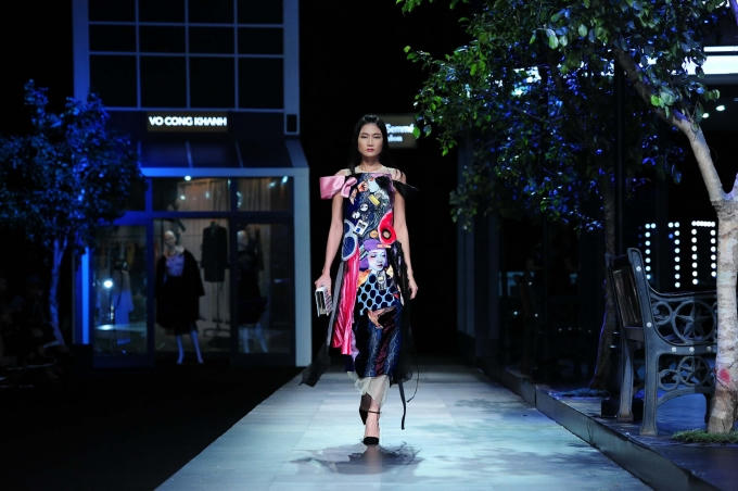 Tiếng nhạc ấn tượng cất lên cũng là lúc chân dài sải những bước đầu tiên trên sàn catwalk, mở màn cho cả show diễn, trong trang phục áo sơ mi dài tay, váy ren tua rua cách điệu, mix cùng áo dáng dài khoác hờ. (Photo: Nghĩa Ngô)