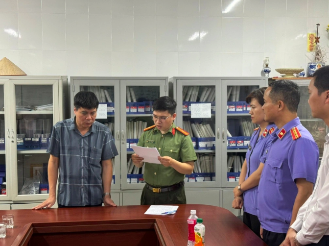Cơ quan điều tra tống đạt các quyết định tố tụng (Ảnh: Công an Hà Nội).