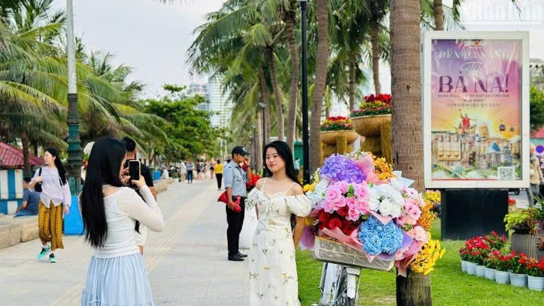 Người dân, du khách thích thú tạo dáng bên cụm hoa nghệ thuật (Ảnh: XUÂN QUỲNH).