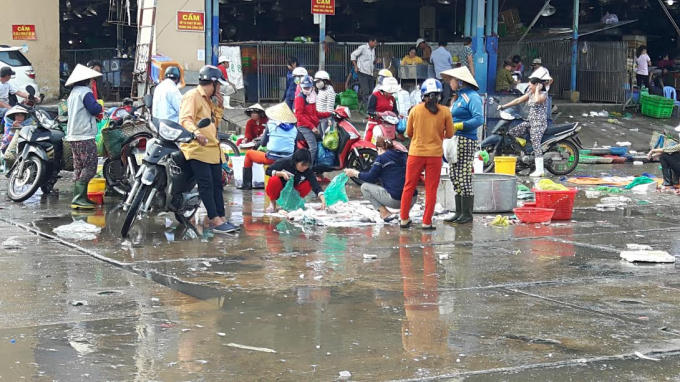 Nước thải từ ngành thủy hải sản chảy lênh láng cả trên mặt nhà lồng lẫn sân chợ Bình Điền.