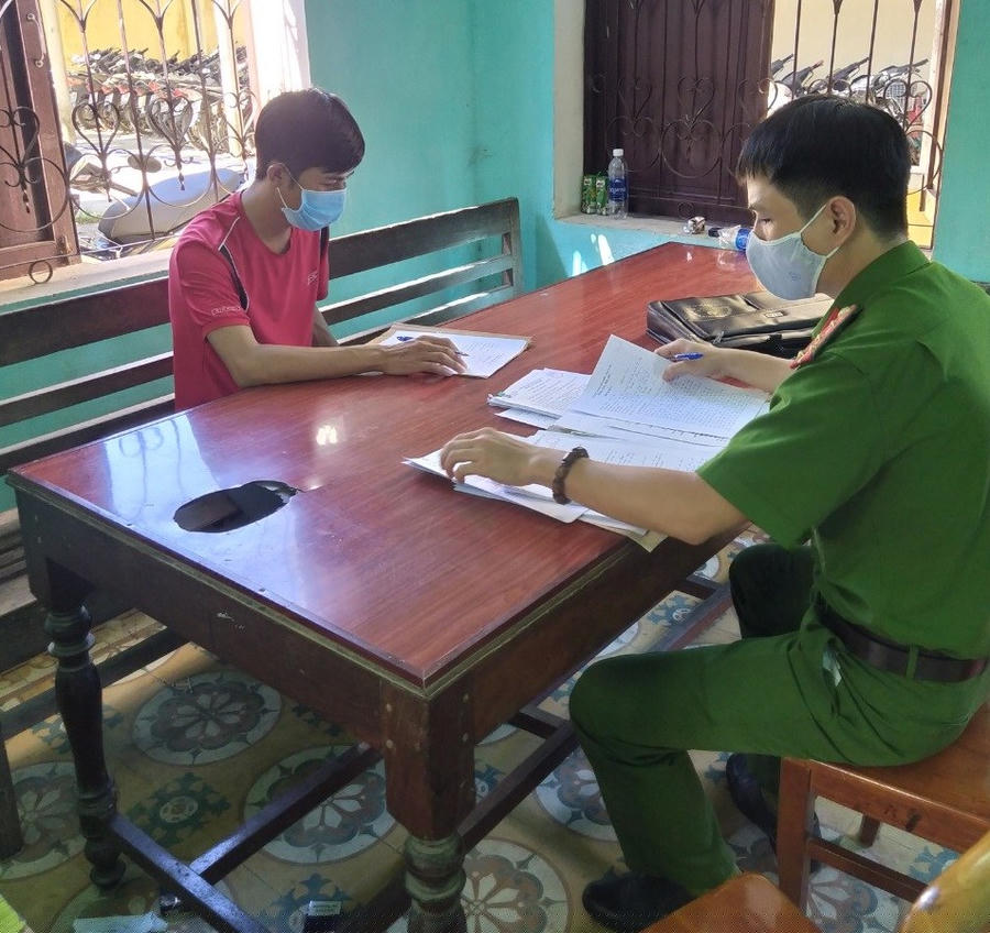 Đối tượng Hoàng Tuấn Tùng (áo đỏ) tại cơ quan Công an.