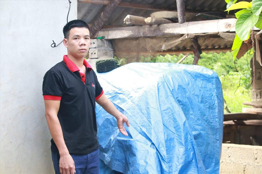 Anh Sơn đứng cạnh bể nước bị đầu độc bằng thuốc diệt cỏ. Ảnh. M.T