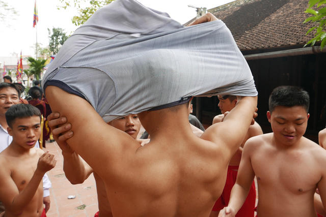 Trong khi đoàn rước pháo đang đi dọc làng trong bầu không khí lễ hội vô cùng sôi động, tại một khoảng sân yên tĩnh bên trong khuân viên đình, các thanh niên lặng lẽ chuẩn bị cho nghi lễ rước quan đám. Đây là những chàng trai tuổi 18 trở lên, thuộc nhiều dòng họ khác nhau trong làng Đồng Kỵ, sẽ đóng vai trò là các trai đinh kiệu đỡ 4 ông đám diễn múa ở phần cao trào của lễ hội.