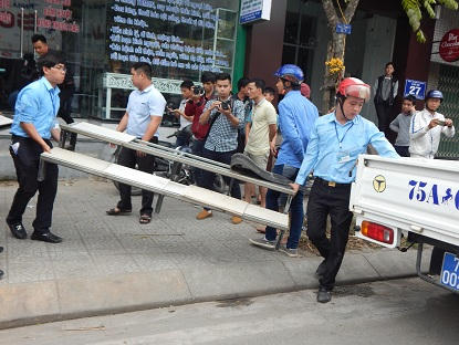 Một kệ để giầy, dép trước một cửa hàng bị tịch thu, đưa lên xe vận chuyển về trụ sở phường.