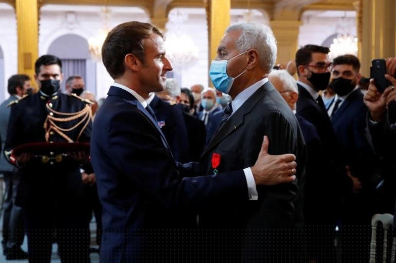 Tổng thống Pháp Emmanuel Macron trao tặng danh hiệu 'Chevalier de la Legion d'honneur' cho một công dân Algeria trong một buổi lễ tưởng nhớ những người Harkis, người Algeria đã giúp đỡ Quân đội Pháp trong Chiến tranh giành độc lập Algeria vào ngày 20/9/2021. Ảnh: AFP