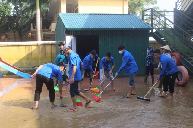 Người dân quét dọn, vệ sinh môi trường tại vùng ngập lụt Chương Mỹ.