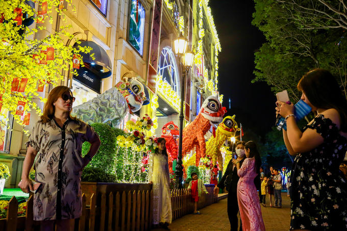Người dân, khách du lịch tham quan và chụp hình không khí Tết tại một trung tâm thương mại đối diện Nhà thờ Đức Bà.