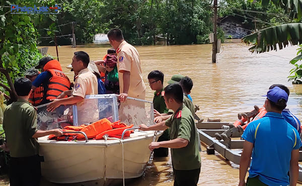 Những chiến sĩ Công an phải liên tục dầm mình trong nước lũ với nỗ lực cứu hộ người dân vào nơi an toàn nhanh nhất. (Ảnh: A.Thắng)