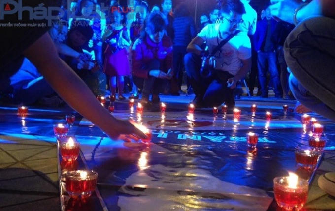 19h15': Hàng trăm bạn trẻ hâm mộ nhạc sĩ, ca sĩ Trần Lập cùng chung tay thắp những ngọn nến lung linh trong đêm nhạc tưởng nhớ đến thủ lĩnh của ban nhạc Bức Tường. Ảnh: Văn Đại.