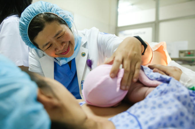 Sau khi giúp sản phụ vượt cạn thành công, nữ bác sĩ chia sẻ niềm vui với mẹ con sản phụ. Bé được nằm áp da trên ngực mẹ.