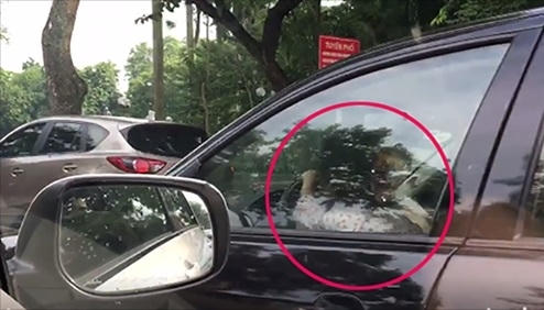 Hình ảnh bé gái cầm vô lăng lái xe trên đường Điện Biên Phủ.