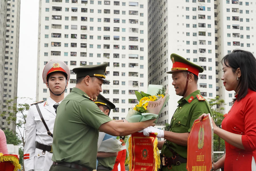 Đại tá Phạm Thanh Hùng, Phó Giám đốc CATP, trao cờ lưu niệm cho các khối dự thi