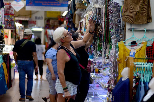 Một vài du khách đến chợ mua hàng.