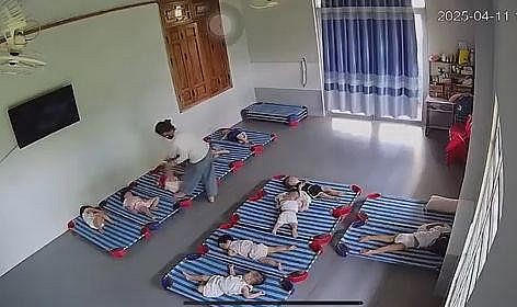 Cháu bé 20 tháng tuổi bị cô giáo xách ngược đánh tới tấp (Ảnh cắt từ clip).
