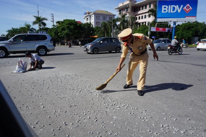 Thấy đá rơi trên đường Trung uý Hưng đã dùng chổi quét, gom số đá này lại để tránh việc người dân tham gia giao thông qua đây gặp phải tai nạn.