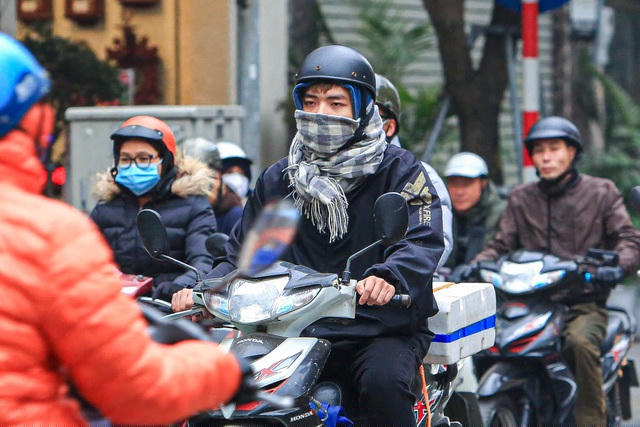 Một người dân quàng kín khăn để ránh cái rét vào sáng sớm.