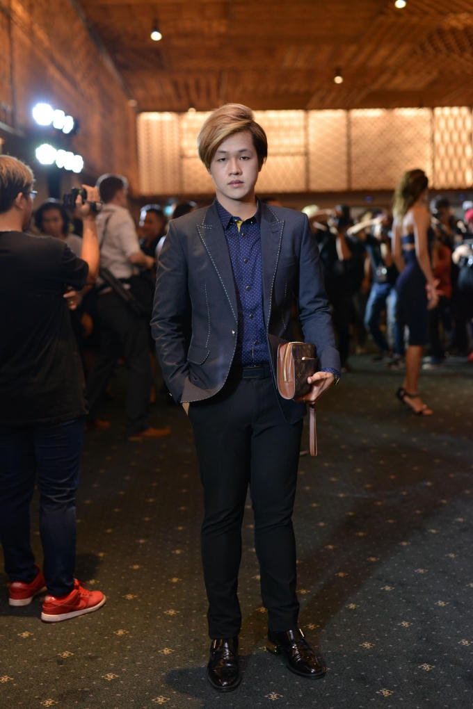 Eric Nguyễn sành điệu với chiếc shirt xanh đến từ thương hiệu Prada, giày nâu sẫm từ nhà mốt Alexander McQueen và clutch của Louis Vuitton.