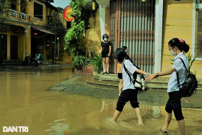 Các bạn trẻ tranh thủ lúc nước đang rút, ở mức độ an toàn để vui chơi, chụp hình khoe bạn bè.