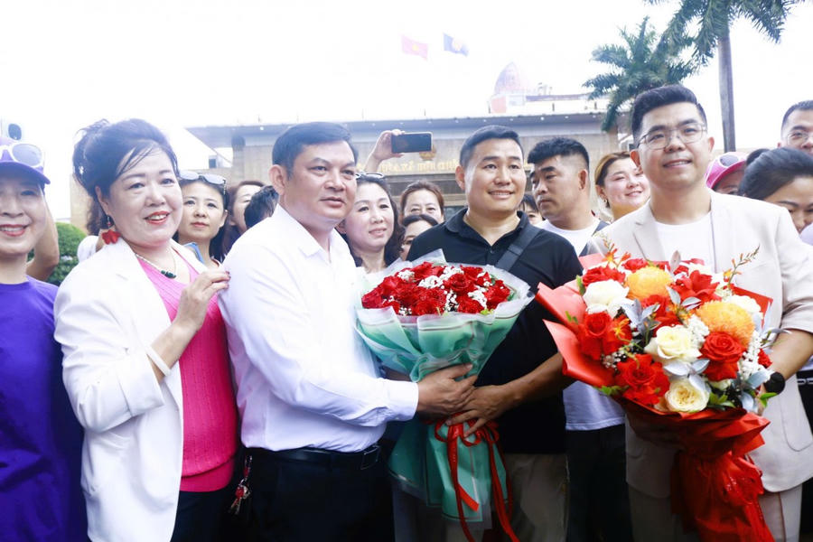 Ông Đỗ Văn Tuấn, Chủ tịch UBND phường Móng Cái 1, tỉnh Quảng Ninh đón, tặng hoa chúc mừng đoàn du khách Trung Quốc.