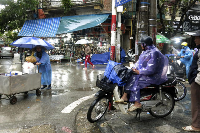 Người lái xe ôm đội mưa chờ khách, công việc kiếm sống hàng ngày trở nên vất vả hơn nhiều.