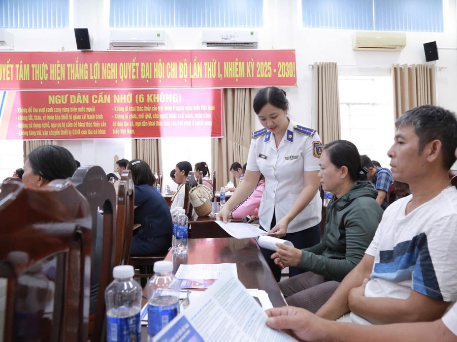 Cán bộ BTL Vùng Cảnh sát biển 4 phát tờ rơi tuyên truyền, cờ tổ quốc cho ngư dân