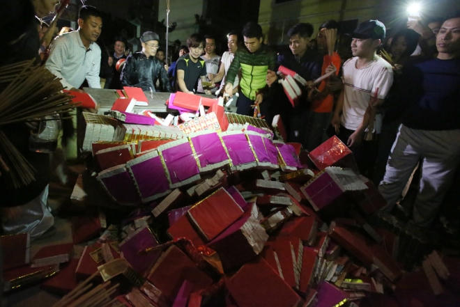 Tất cả vàng mã được đưa ra sân đình. Lửa mồi được lấy trên ban thờ bằng một cây sào dài.