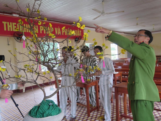 Thượng tá Võ Văn Nghệ, Phó Giám thị, hướng dẫn phạm nhân trang trí hoa mai (ảnh Phương Nam).