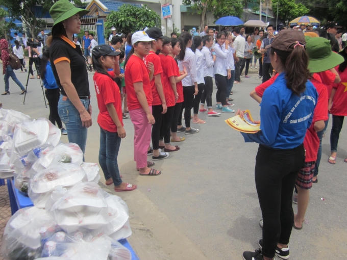 Các tình nguyện viên xếp hàng phục vụ thí sinh.