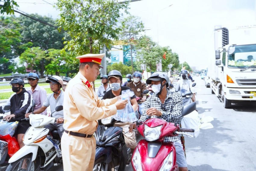 CSGT hỗ trợ phát nước cho người dân đi đường.